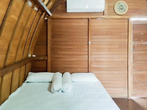 a small bed in a room with wooden walls at The Lavana Villa LDR Bandar Lampung in Lampung