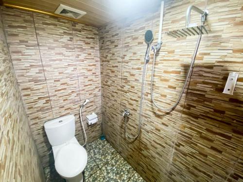 uma casa de banho com um chuveiro e um WC. em The Lavana Villa LDR Bandar Lampung em Lampung