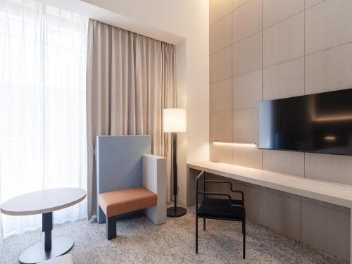a hotel room with a desk with a tv and a chair at Hotel Il Palazzo in Fukuoka
