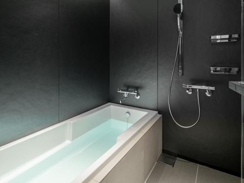 a bathroom with a bath tub and a shower at Hotel Il Palazzo in Fukuoka