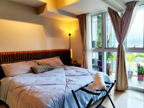 um quarto com uma cama e uma grande janela em 4 Pax Cozy Uptown Mall Unit with Balcony and Parking em Manila