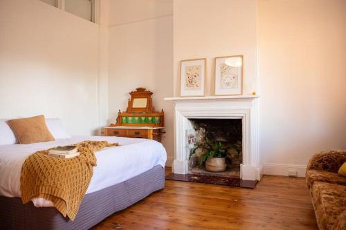 ein Schlafzimmer mit einem Bett und einem Kamin in der Unterkunft Coolamon School of Arts 