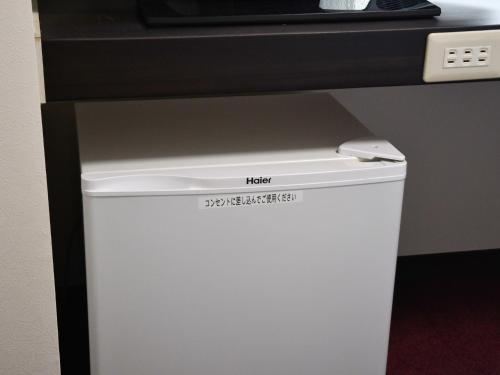 a small white refrigerator under a counter in a room at ＦＯＲＢＥＬＬ　ＳＴＡＹ　ＹＵＲＩＧＡＯＫＡ in Ikuta