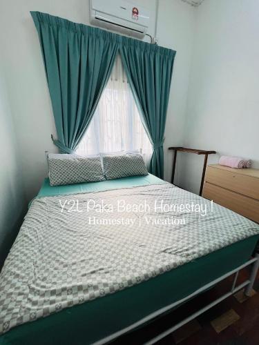 a bedroom with a bed with green curtains and a window at Traveler Homestay Paka 3-6pax in front Surau and Near Paka Beach - Y2L Homestay 1 in Paka
