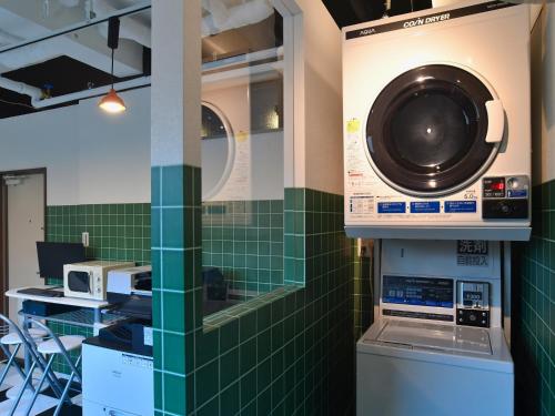 a washer and dryer in a room with green tiles at ＦＯＲＢＥＬＬ　ＳＴＡＹ　ＹＵＲＩＧＡＯＫＡ in Ikuta