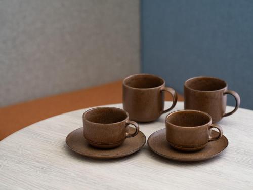 three coffee cups and saucers on a table at Hotel Il Palazzo in Fukuoka