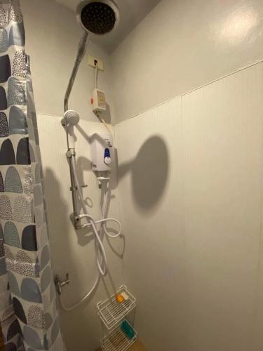 een badkamer met een douche in de hoek van een kamer bij Eri transient house Tagum in Tagum