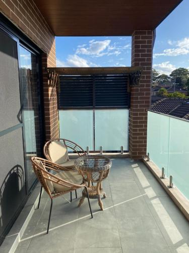 a patio with a table and chairs on a balcony at Penshurst Guest House in Sydney