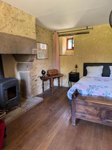 a bedroom with a bed and a fireplace at LE DOMAINE DE COAT ROGAN, La chambre du Tregor in Ploëzal