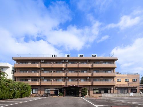 a large building with a parking lot in front of it at Tabist Hotel Yamashiro Onsen in Kofu