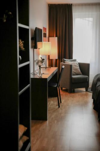a room with a desk with a chair and a couch at Quality Hotel Grand Falun in Falun