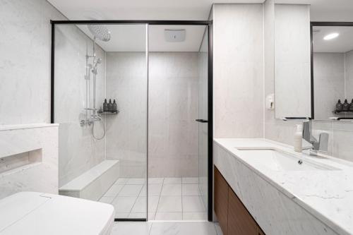 een badkamer met een douche, een toilet en een wastafel bij Le Collective Gangnam SAC Signity in Seoul