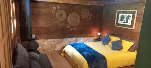 a bedroom with a bed and a wall with a painting at La Tierra Grande in Zacatlán