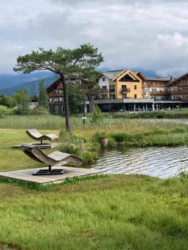 two benches sitting next to a body of water at RELAX Seefeld Apartman in Seefeld in Tirol