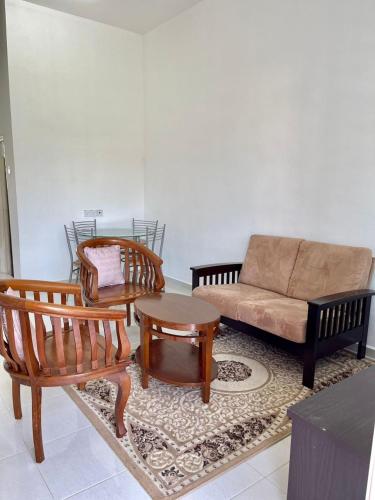 ein Wohnzimmer mit einem Sofa und 2 Stühlen in der Unterkunft Rumah Kami Homestay in Butterworth