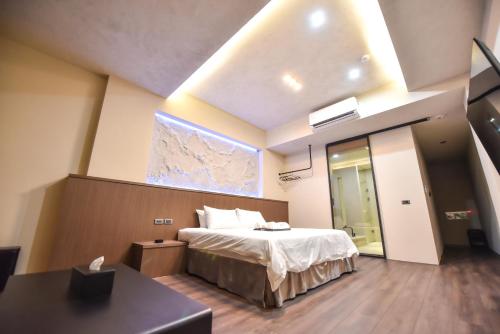 a bedroom with a bed and a large window at Two Couples Leisure Art Motel in Tainan