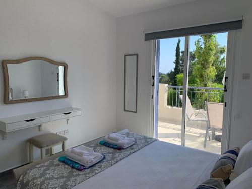a bedroom with a bed and a mirror and a balcony at Paradise Gardens 3 - superb 1 bed apartment in Paphos