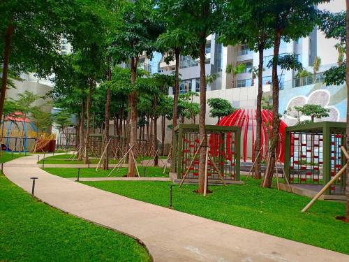 un parc avec une aire de jeux arborée et un trottoir dans l'établissement Studio 17 Taman Anggrek Residence Best Cozy and Stay 50mbps Wifi, à Jakarta
