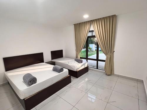 a bedroom with two beds and a large window at TheDot 903 @ A’Famosa Villa NEW VILLA in Kampong Alor Gajah
