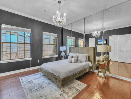 a bedroom with a large bed and a chandelier at LUX 4BR Home w/ Hot tub & Pool, 15 min to downtown in Houston
