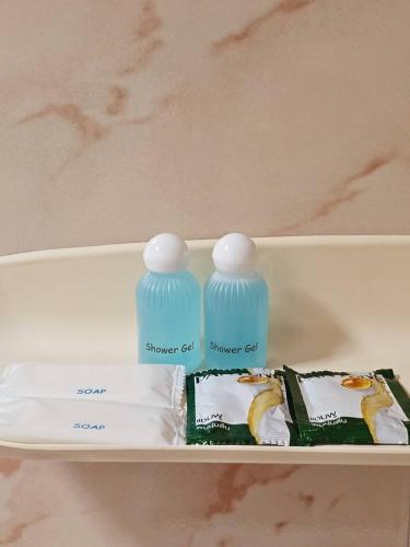 two blue bottles sitting on top of a shelf at P.California Inter Hostel in Nang Rong