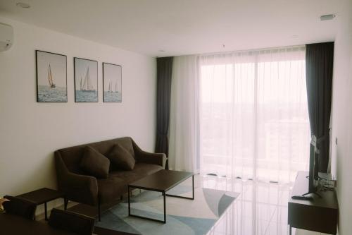a living room with a couch and a window at Ramada Suites by Wyndham The Straits Johor Bahru in Johor Bahru
