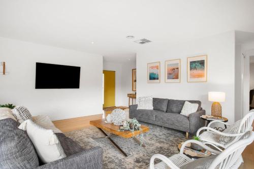 a living room with a couch and a tv at Macks Family Hideout in Safety Beach