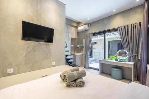 a bedroom with a bed with a tv on the wall at BLANCA8 - 21 - Bali Invest Club in Canggu