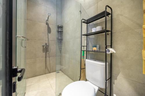 ein Badezimmer mit einer Dusche und einem WC mit einer Glastür in der Unterkunft BLANCA8 - 21 - Bali Invest Club in Canggu