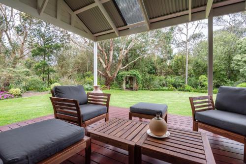 a porch with two chairs and a table at Inglewood Gardens in Rosebud