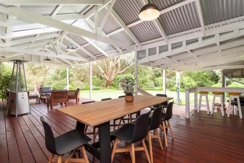 a large deck with a wooden table and chairs at Inglewood Gardens in Rosebud