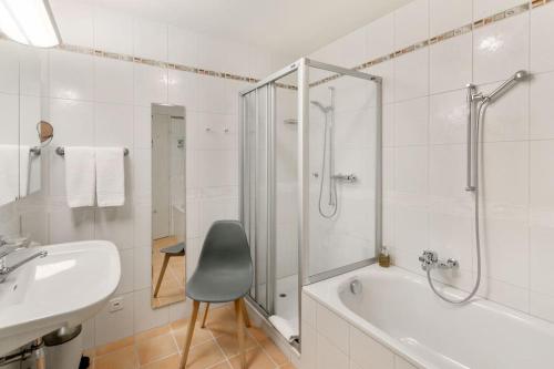 a bathroom with a tub and a sink and a shower at Alpes - Large apartment with amazing view on Lake Geneva in Montreux