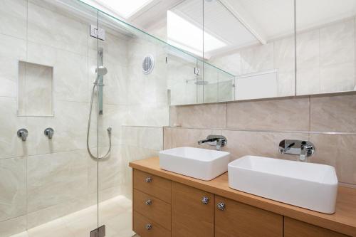 a bathroom with two sinks and a shower at Blairgowrie Beauty By The Beach in Blairgowrie