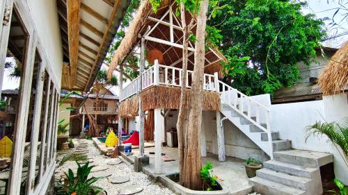 吉利特拉旺安Panda Home的一座有树屋的建筑,有楼梯