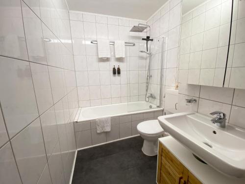 Baño blanco con aseo y lavamanos en Apartment Neuss-Düsseldorf Messe en Neuss