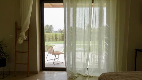 a bedroom with a sliding glass door to a patio at Pnoe Eco Residences in Amaliás