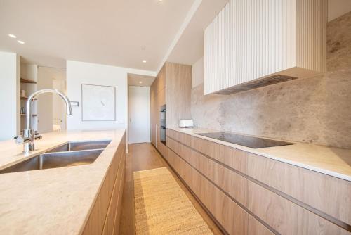 a kitchen with wooden cabinets and a sink at Oceano Residence Mornington in Mornington