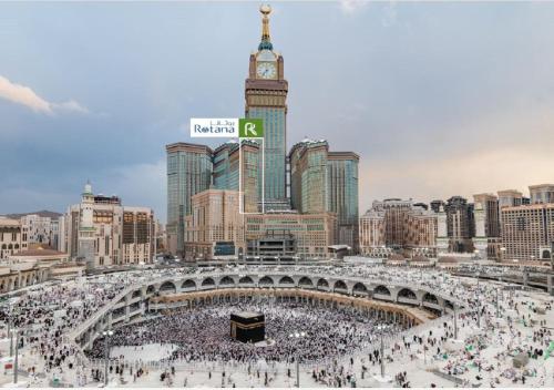 una grande folla di persone davanti a una torre dell'orologio. di Al Marwa Rayhaan by Rotana - Makkah a La Mecca
