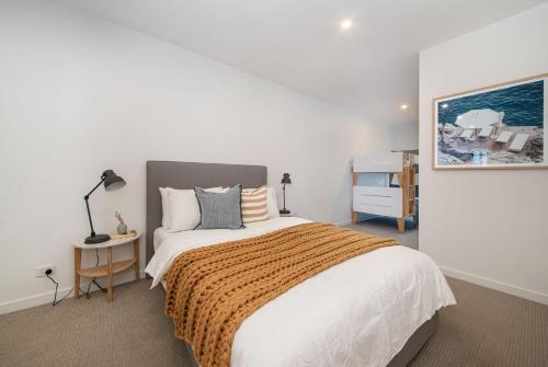 a bedroom with a large bed and a desk at Apartment Living on the Beach in Rosebud