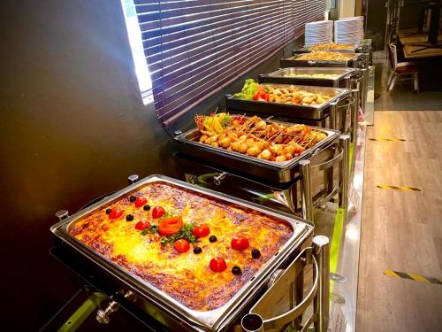 a row of trays filled with food in a restaurant at Park Avenue Hotel Sungai Petani in Sungai Petani