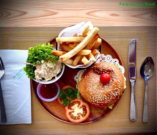 a plate of food with a hamburger and french fries at Park Avenue Hotel Sungai Petani in Sungai Petani