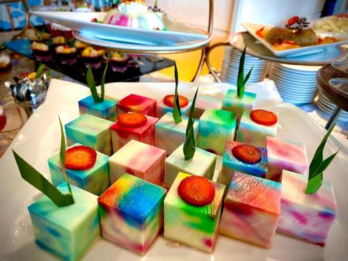 a white table topped with colorful cakes and strawberries at Park Avenue Hotel Sungai Petani in Sungai Petani
