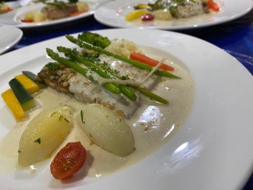 a white plate of food with vegetables on a table at Park Avenue Hotel Sungai Petani in Sungai Petani