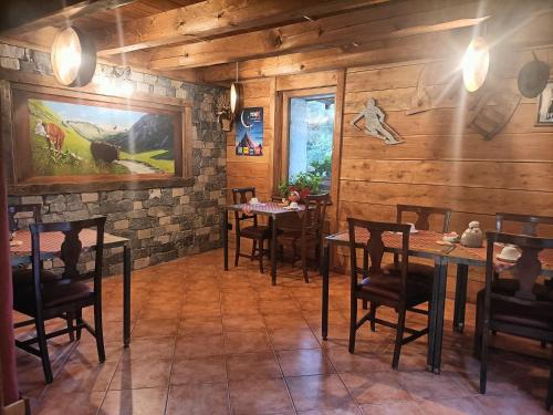 a dining room with wooden walls and tables and chairs at La Barma in Pré-Saint-Didier