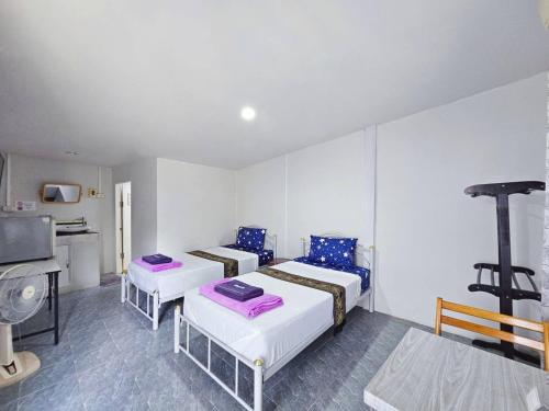 a room with two beds and a tv in it at P.California Inter Hostel in Nang Rong