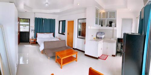 a room with a bed and a couch and a table at LUNA OSLOB TRAVELLERS INN - Beach Front in Oslob