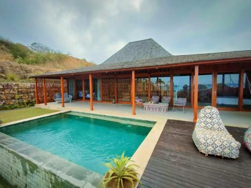a villa with a swimming pool and a house at Lobster Bay Lombok in Awang