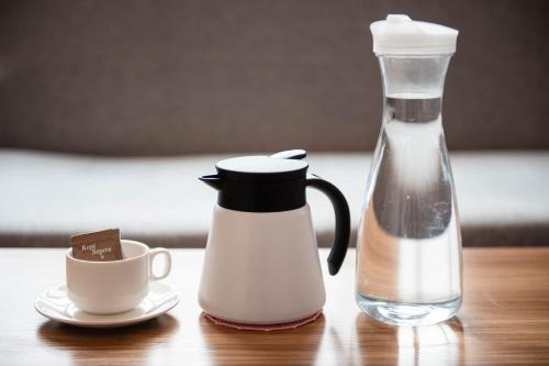 una bottiglia di latte e una tazza di caffè sul tavolo di Hotel Meliden a Sandakan