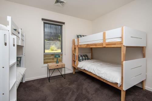 a bedroom with two bunk beds and a window at Luxury and Style on Pasadena with large spa in Rye
