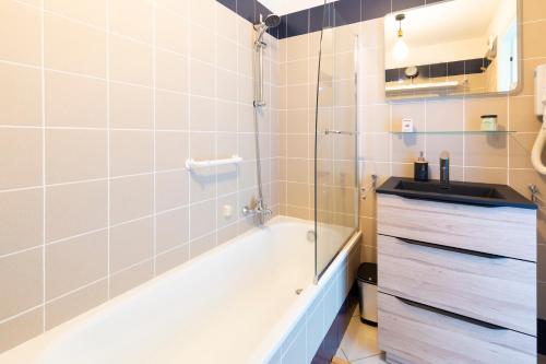 y baño con bañera y lavamanos. en BEAUSEJOUR - PISCINE - PARKING - Monaco en Beausoleil